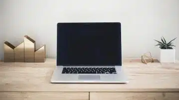 un ordinateur sur un table en bois
