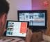 man browsing tablet sitting in front of TV