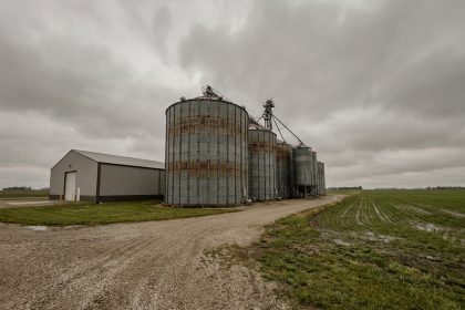 Installations industrielles de stockage agricole avec silos en acier galvanisé et entrepôt moderne dans un paysage rural